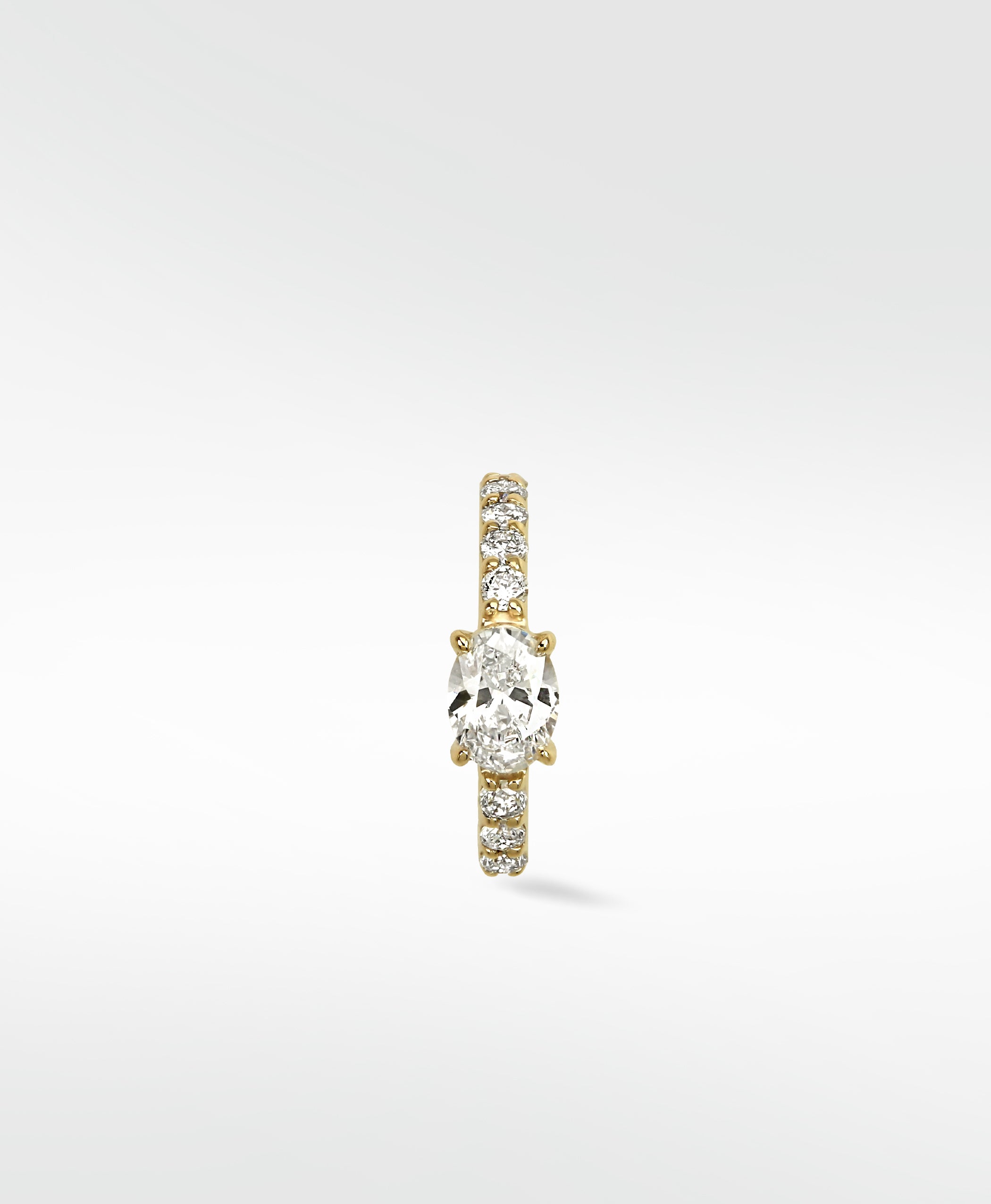 Front view of the Modernist Oval Diamond Hoop with a central oval diamond and a pavé diamond band set in yellow gold.