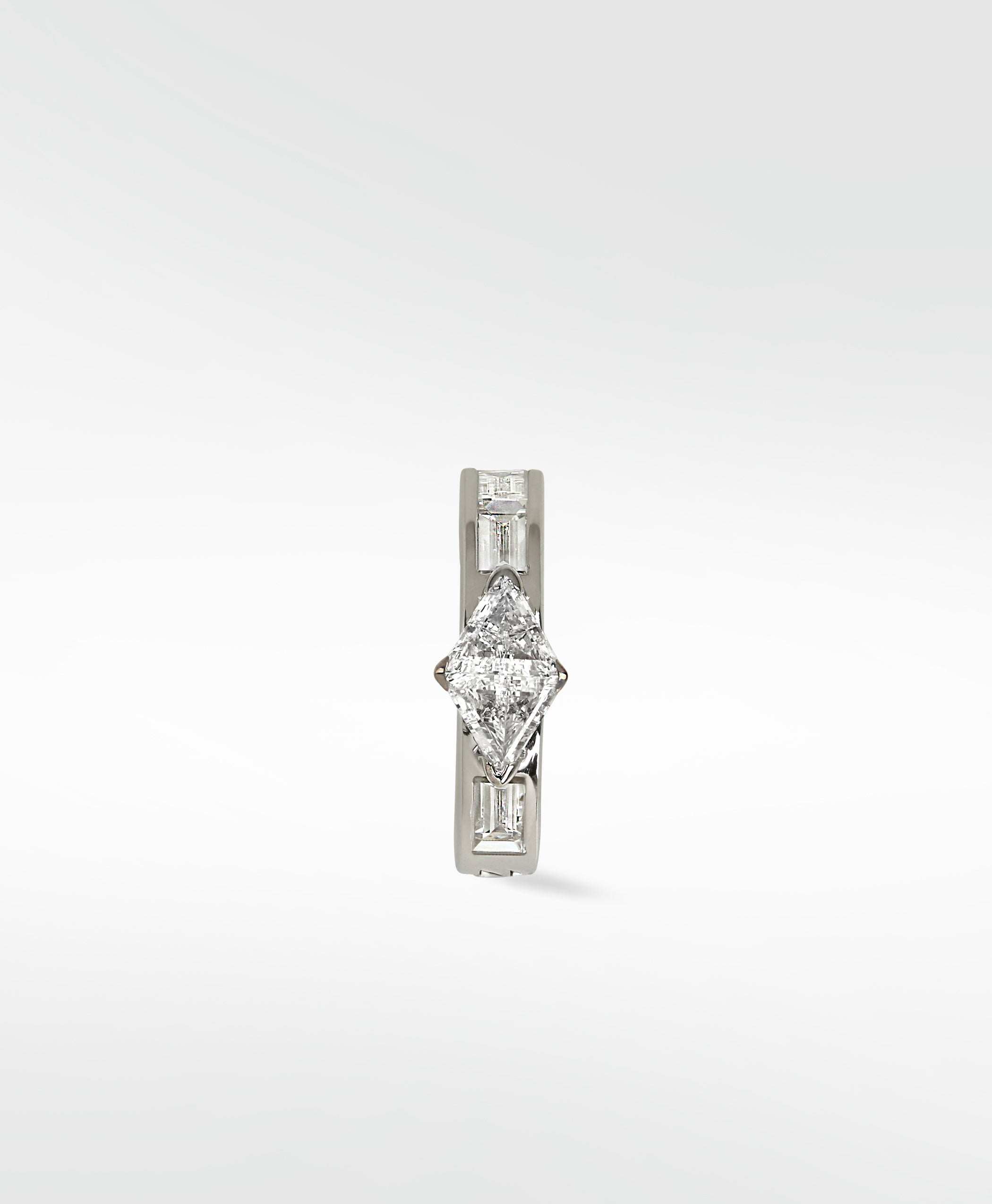 A white gold Modernist hoop earring with a central triangle diamond and baguette diamond accents, on a white background.