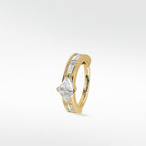 A yellow gold Modernist hoop earring featuring a central triangle diamond and channel-set baguette diamonds on a white background.